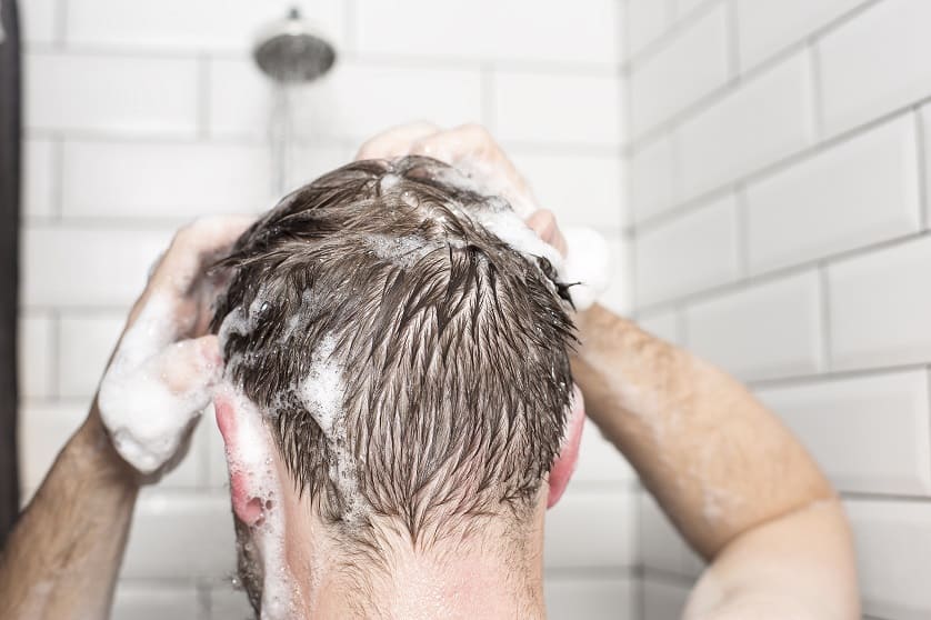Hombre lavándose el cabello con champú