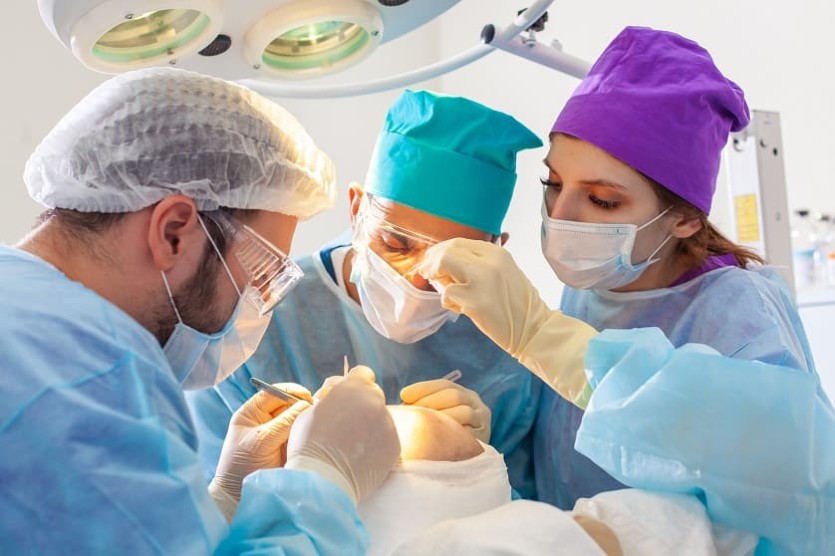 Equipo de profesionales realizando un trasplante capilar