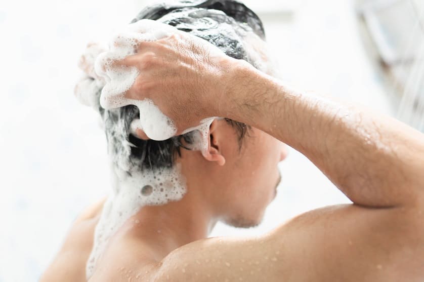 Mann wäscht Haare nach der Haartransplantation