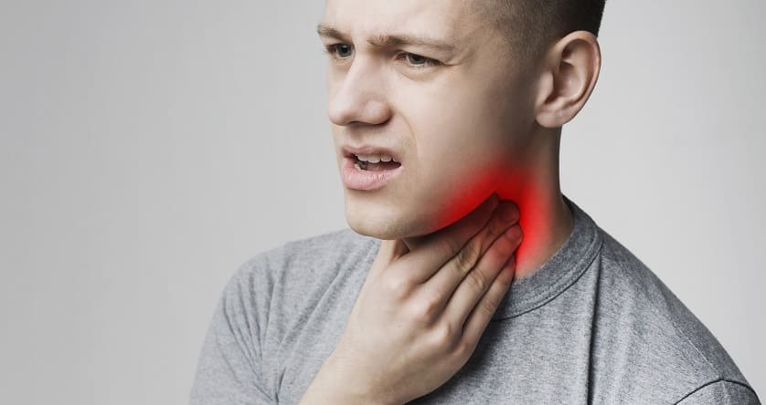 Mann fässt sich an den Hals aufgrund von Schilddrüsenprobleme