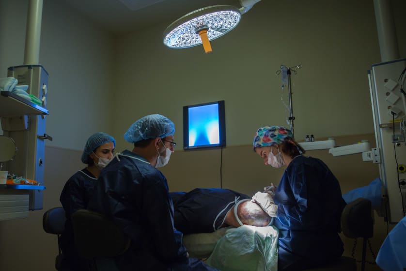 Ärzte führen eine Haartransplantation bei einem männlichen Patienten durch