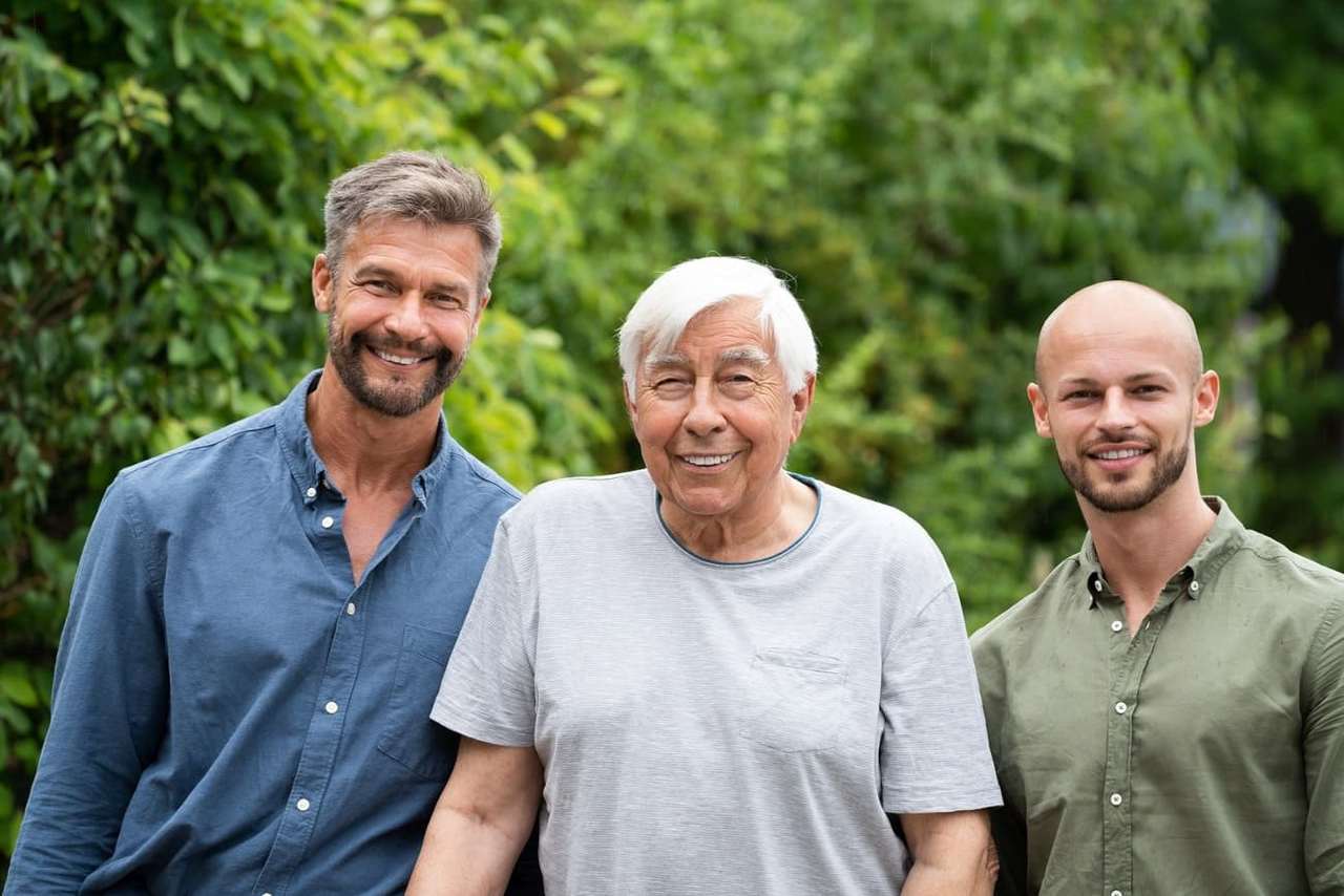Drei Männer mit unterschiedlichem Alter stehen nebeneinander.